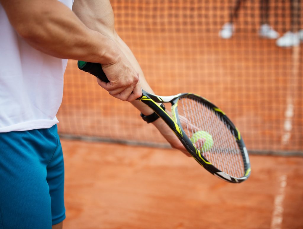 Tennis player prepares to serve ball during tennis match